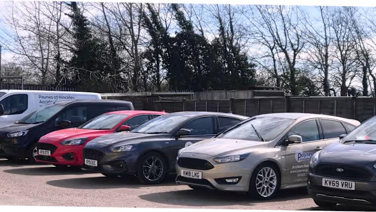 Selection of used Ford vehicles parked at a dealership forecourt, including hatchbacks and vans.