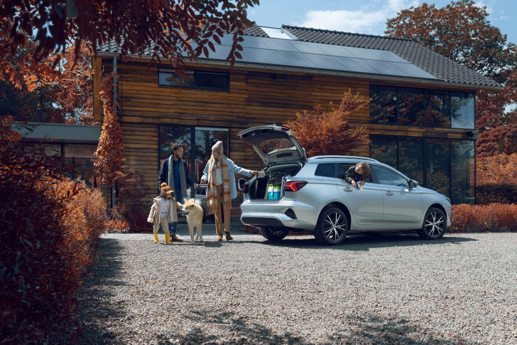 Silver car parked outside house with family loading car