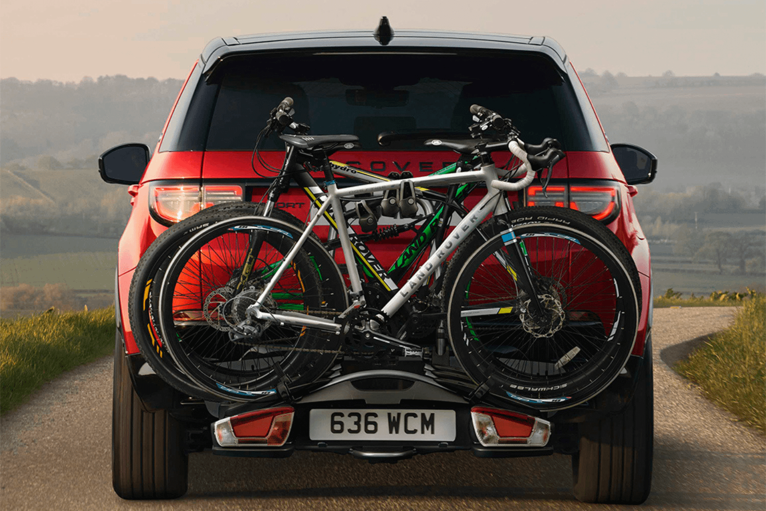 Land Rover Discovery carrying two bicycles on rear-mounted bike rack.