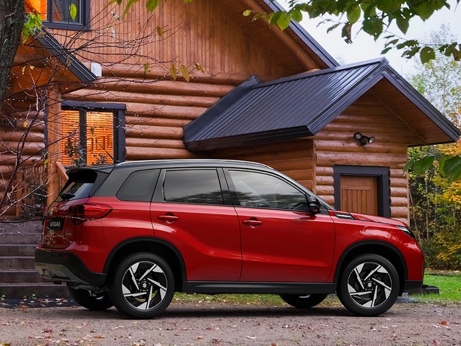 red Suzuki Vitara by a house