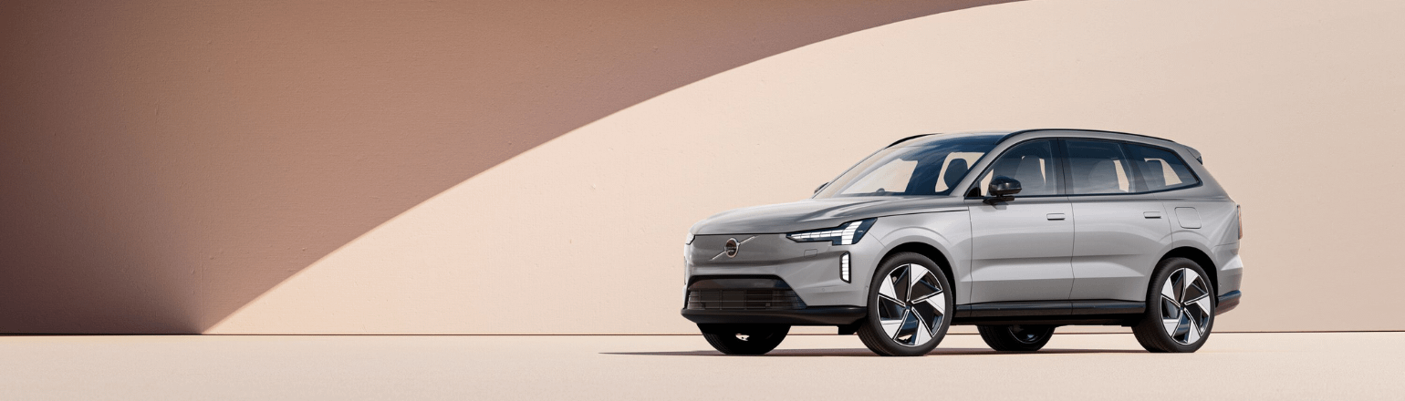 Silver Volvo SUV parked against modern architectural backdrop.