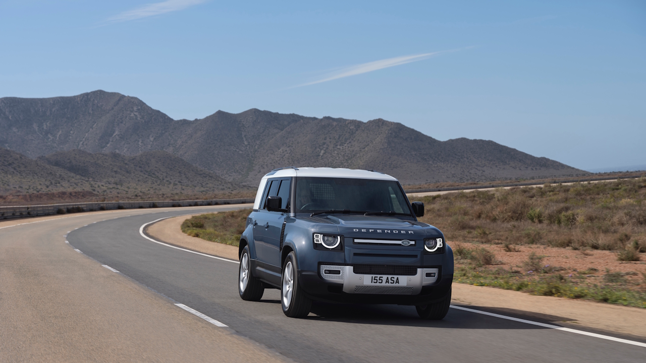 Front three-quarter view of the Defender Hard Top driving along a winding mountain road.