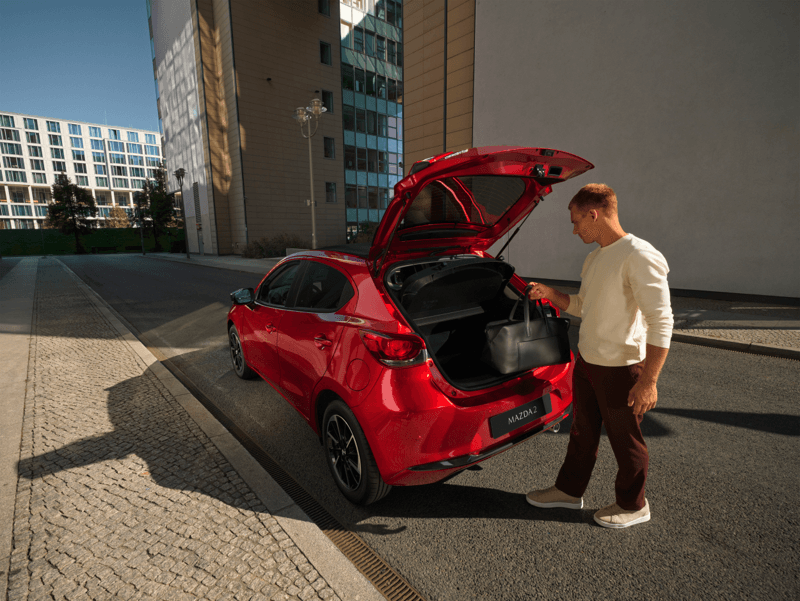 man opening the boot of a MAzda 2