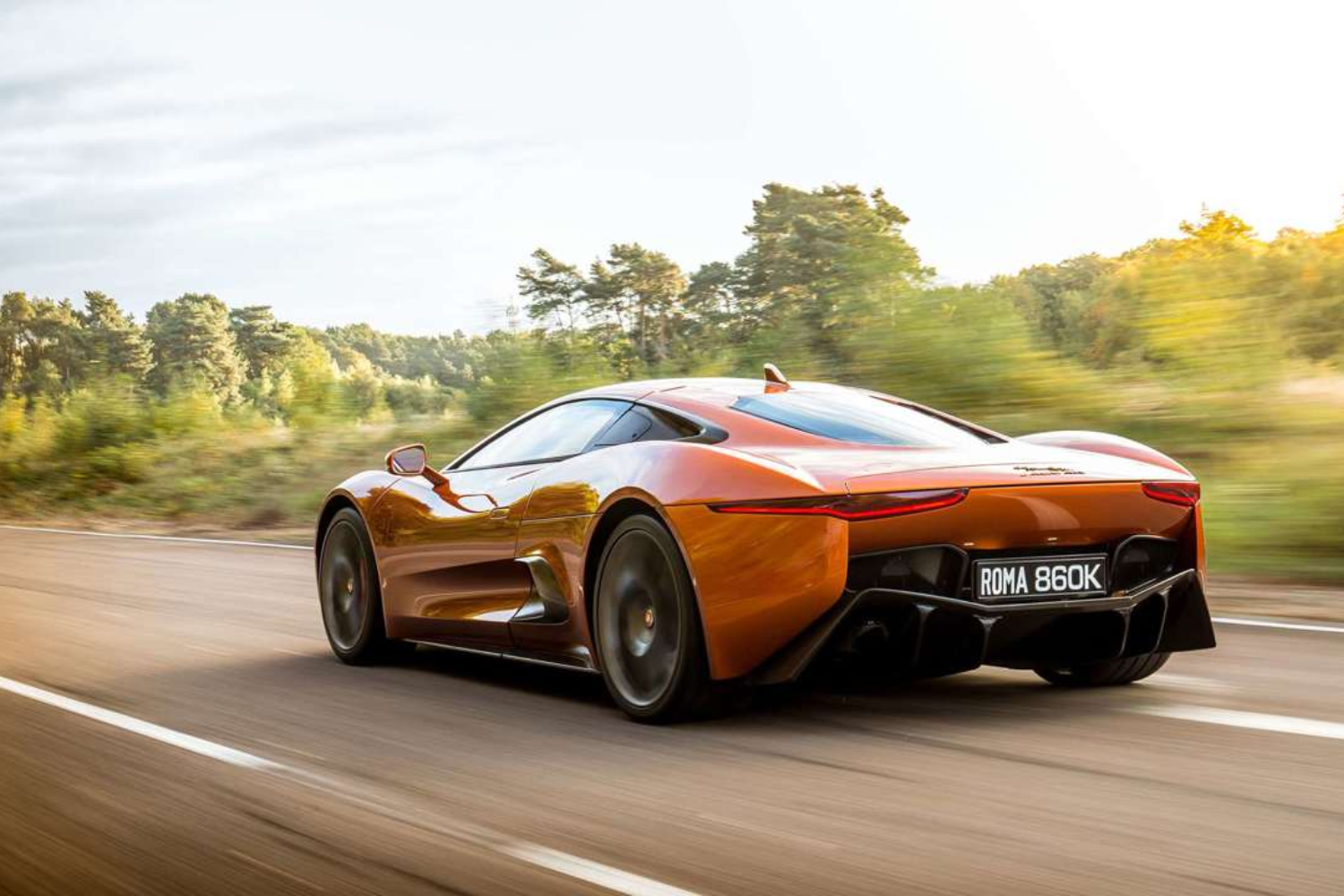 Rear three-quarter view of Roma 860k sports car in motion.
