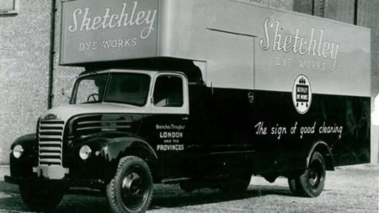 Black and white delivery truck from Sketchley Dye Works, displaying company branding and parked outdoors.