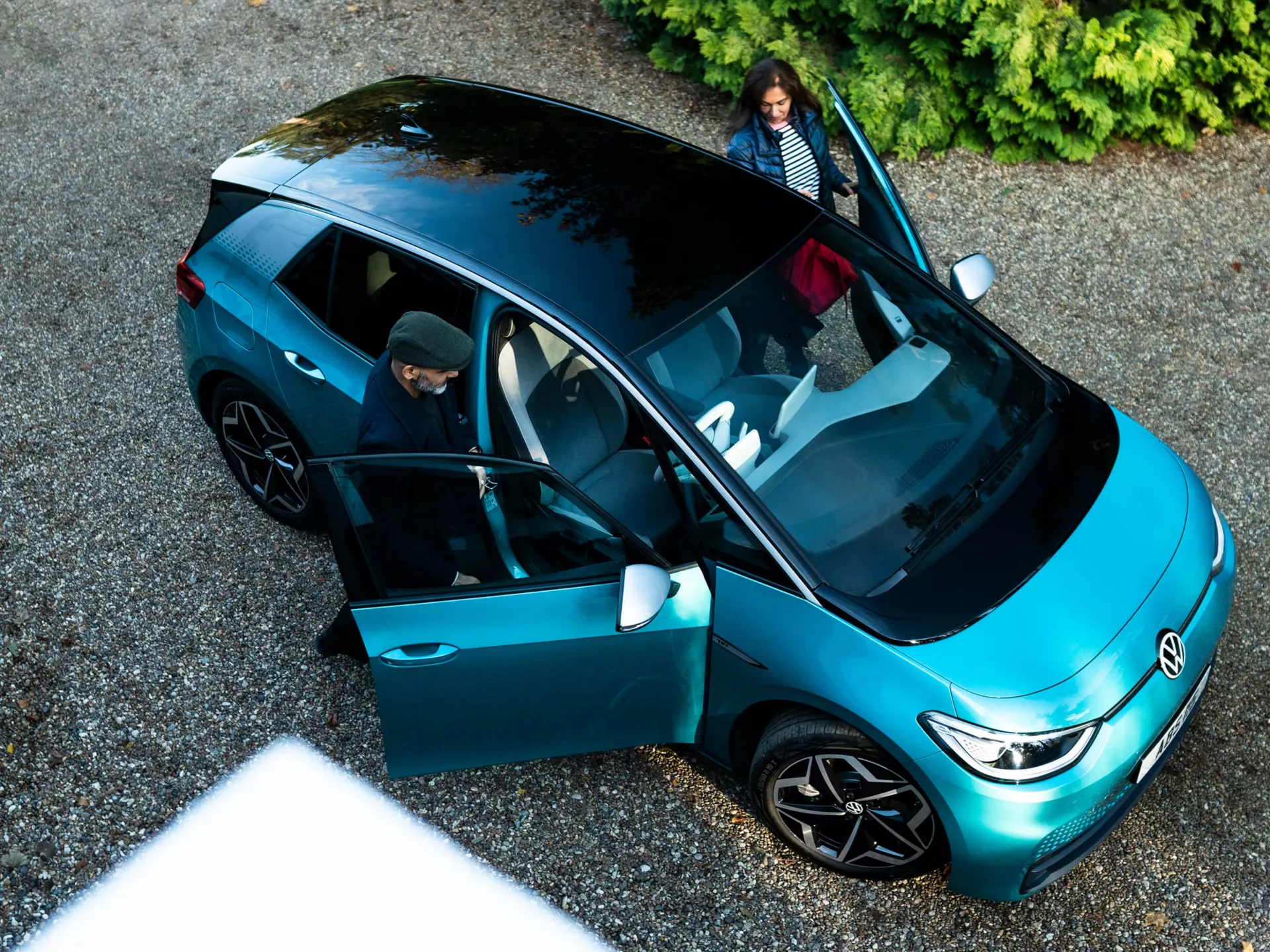 Blue Volkswagen ID.3 Exterior, looking down at couple getting into ID.3, can see roof, bonnet and side of the car