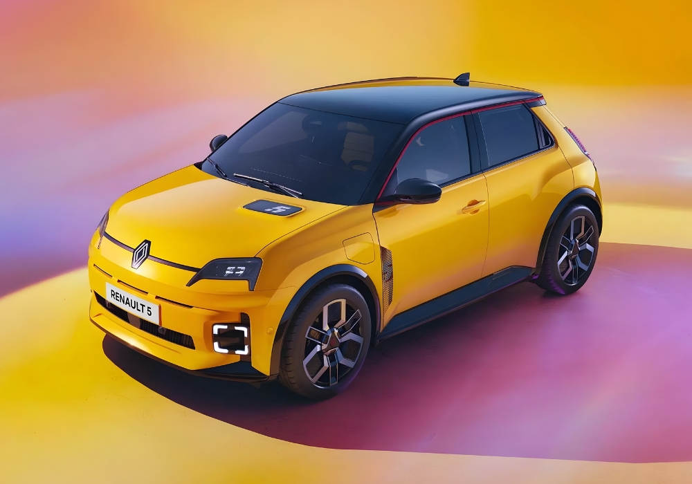 Yellow Renault 5 E-Tech electric hatchback in a studio setting, shown from an elevated front angle.