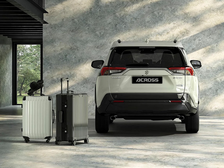 luggages beside a white Suzuki Across