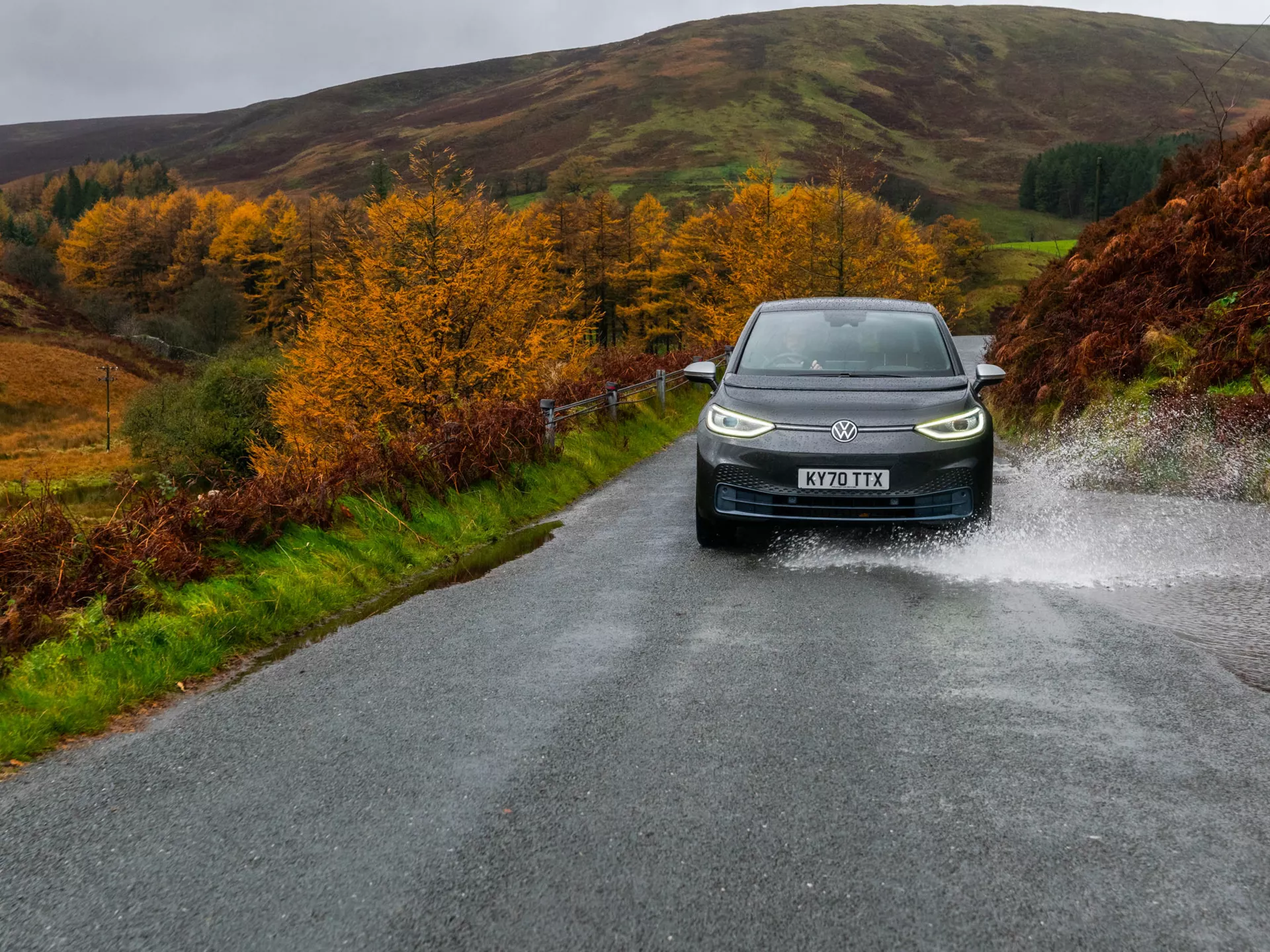 Black Electric Volkswagen ID3 driving through puddle, front view