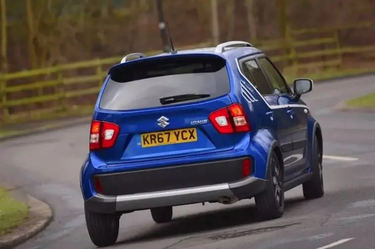Blue Suzuki Ignis rear view driving along road