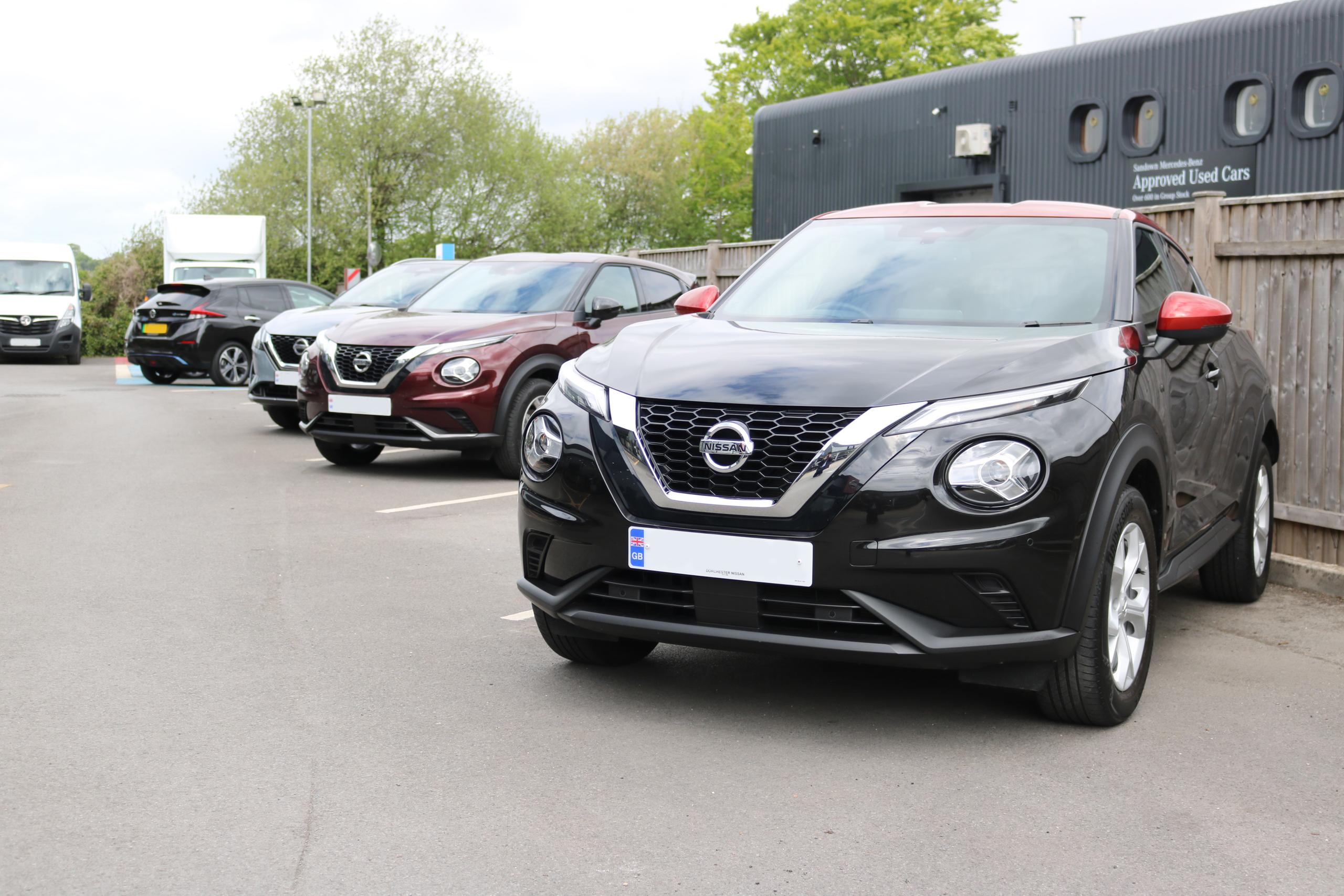 Cars lined up outside nissan dealership.