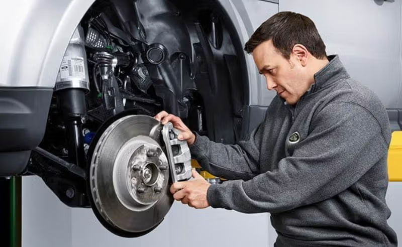 Audi Mechaninc Inspecting Brake Disc