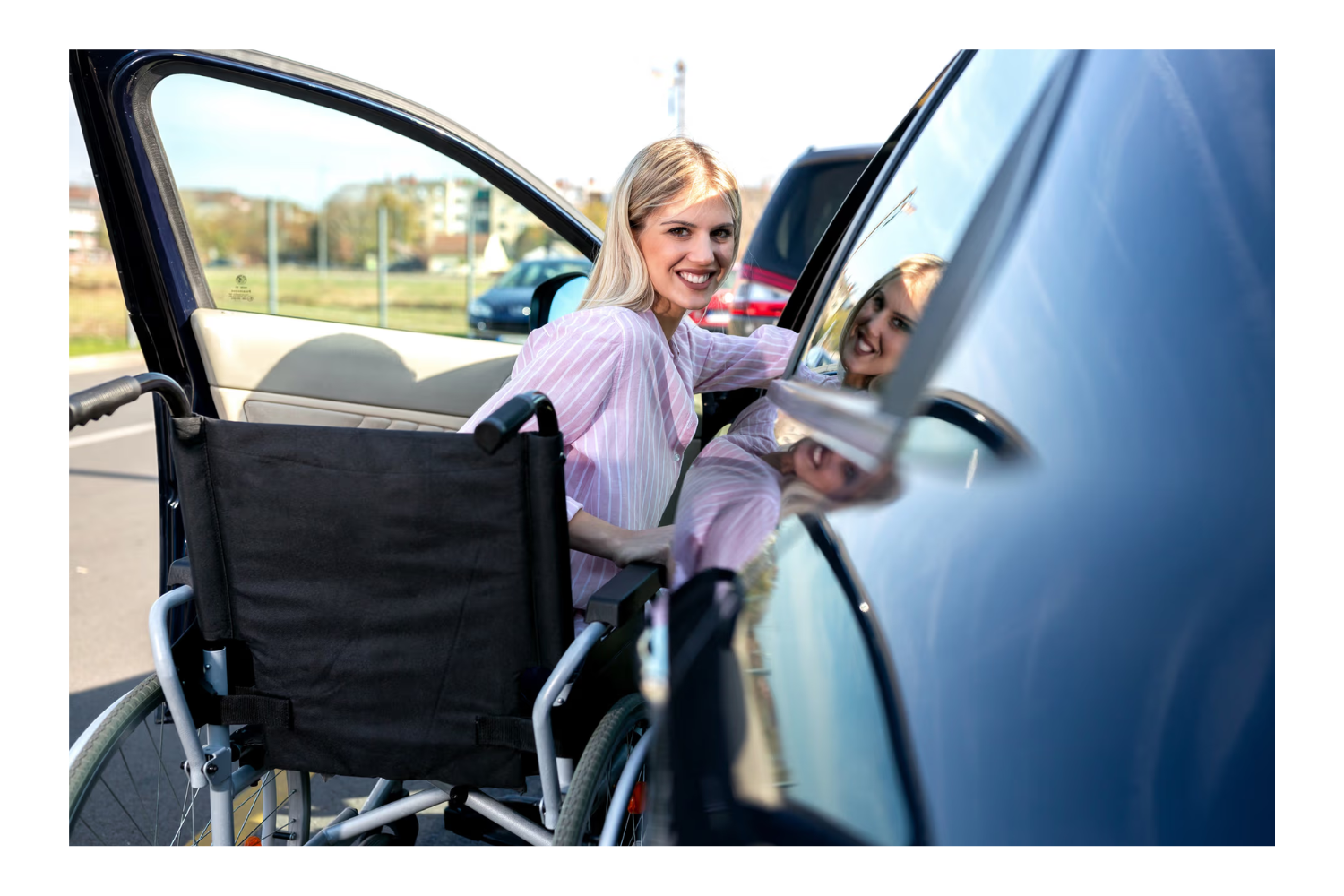 Woman in a wheelchair getting into a car