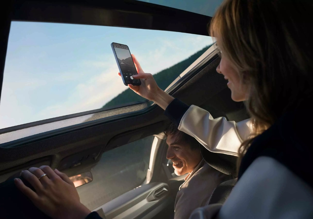 Dacia Duster interior with passengers enjoying panoramic roof view, highlighting comfort and scenic visibility.