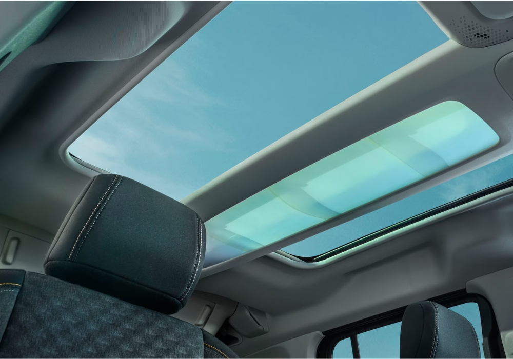 Interior view of Peugeot E-Rifter highlighting the panoramic glass roof and rear seating area.