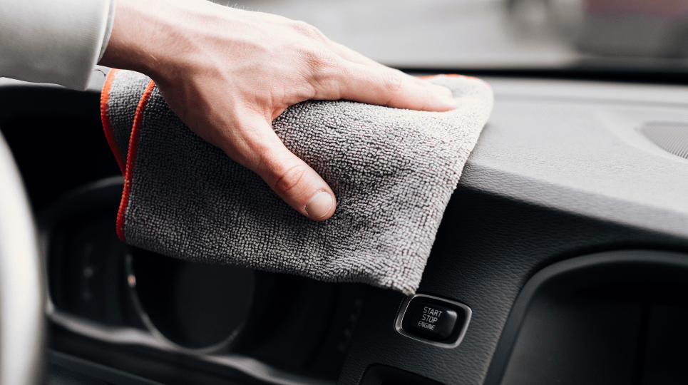 wiping car dashboard with grey cloth