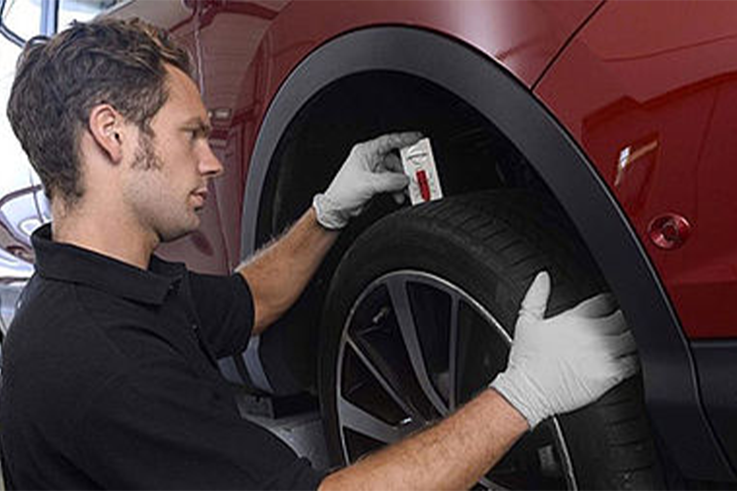 man checking tyre tread depth