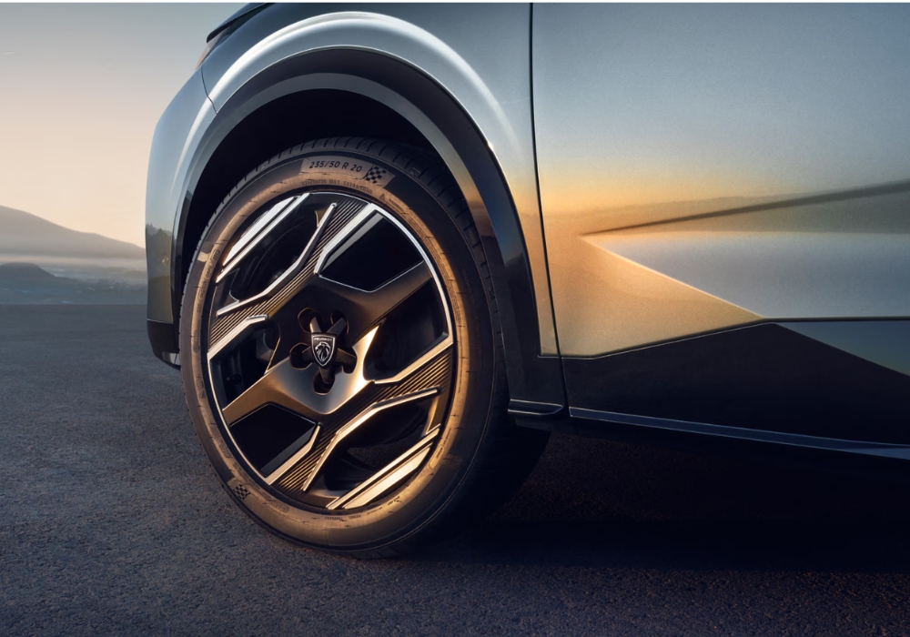 Close-up of Peugeot E-5008 alloy wheel and sculpted side body panel with metallic finish.