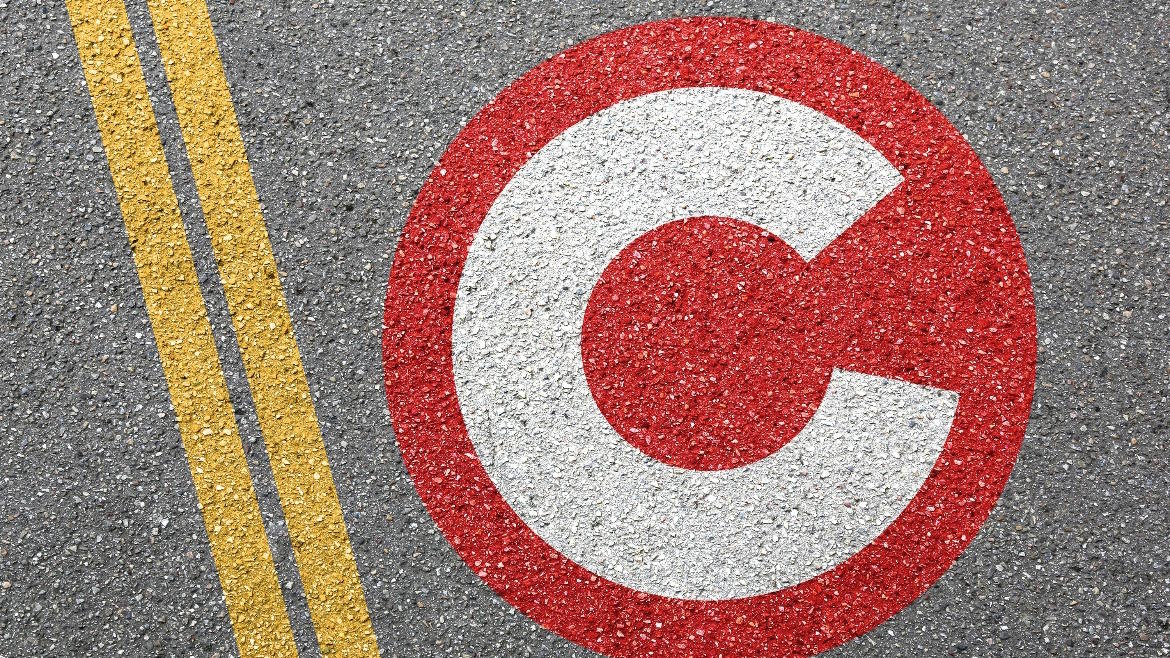 Red and white public charging marker beside double yellow lines.