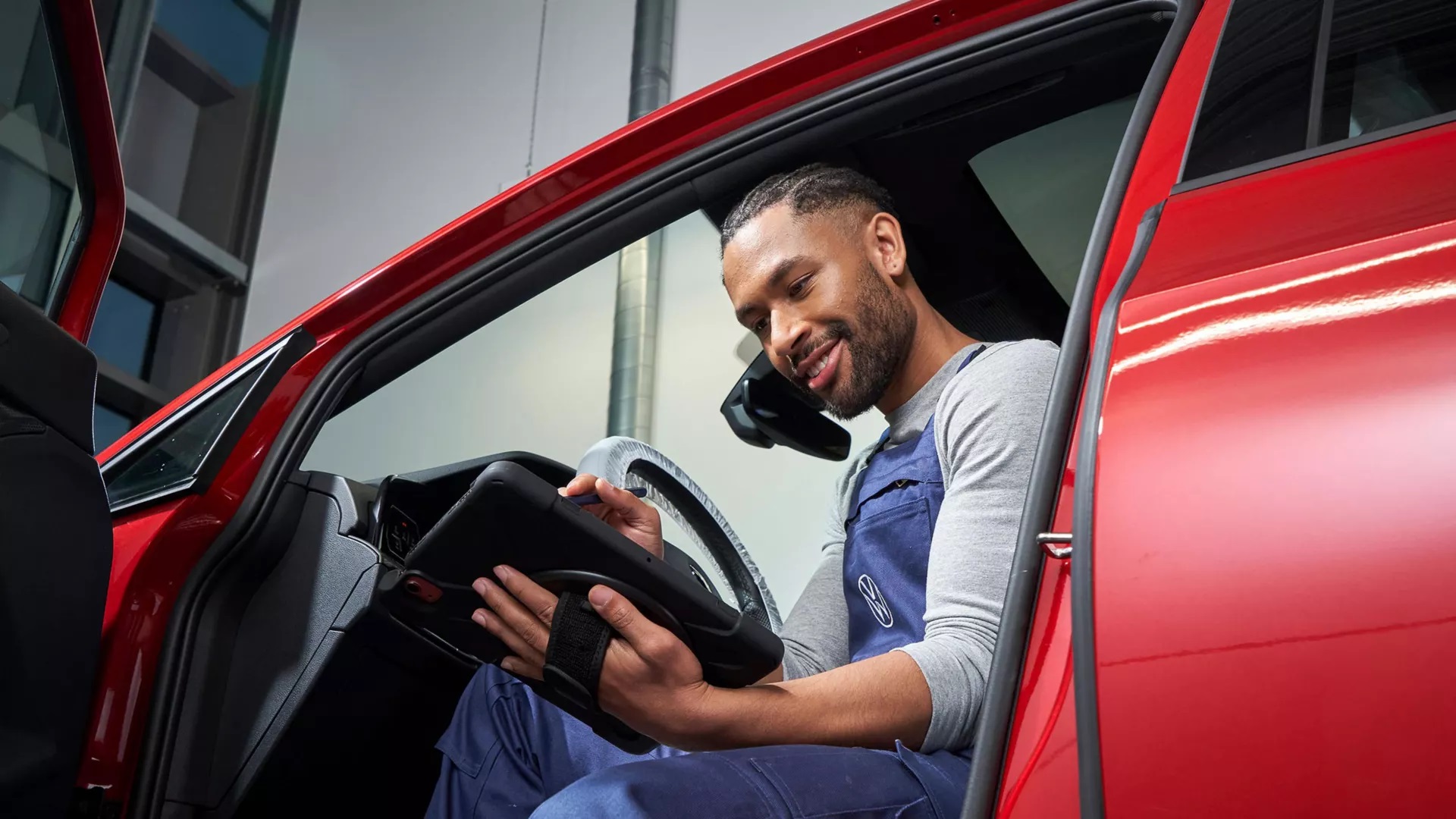 Mechanic Sat In VW Vehicle holding a tablet
