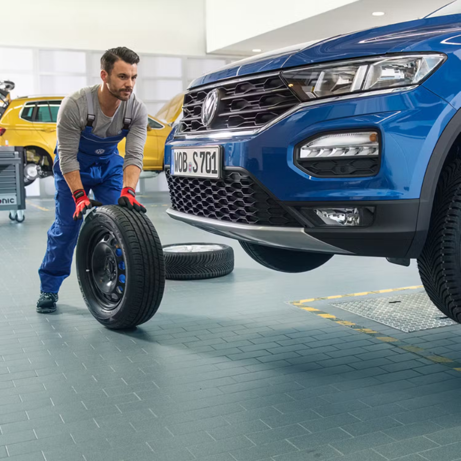 Volkswagen Mechanic Rolling a Tyre