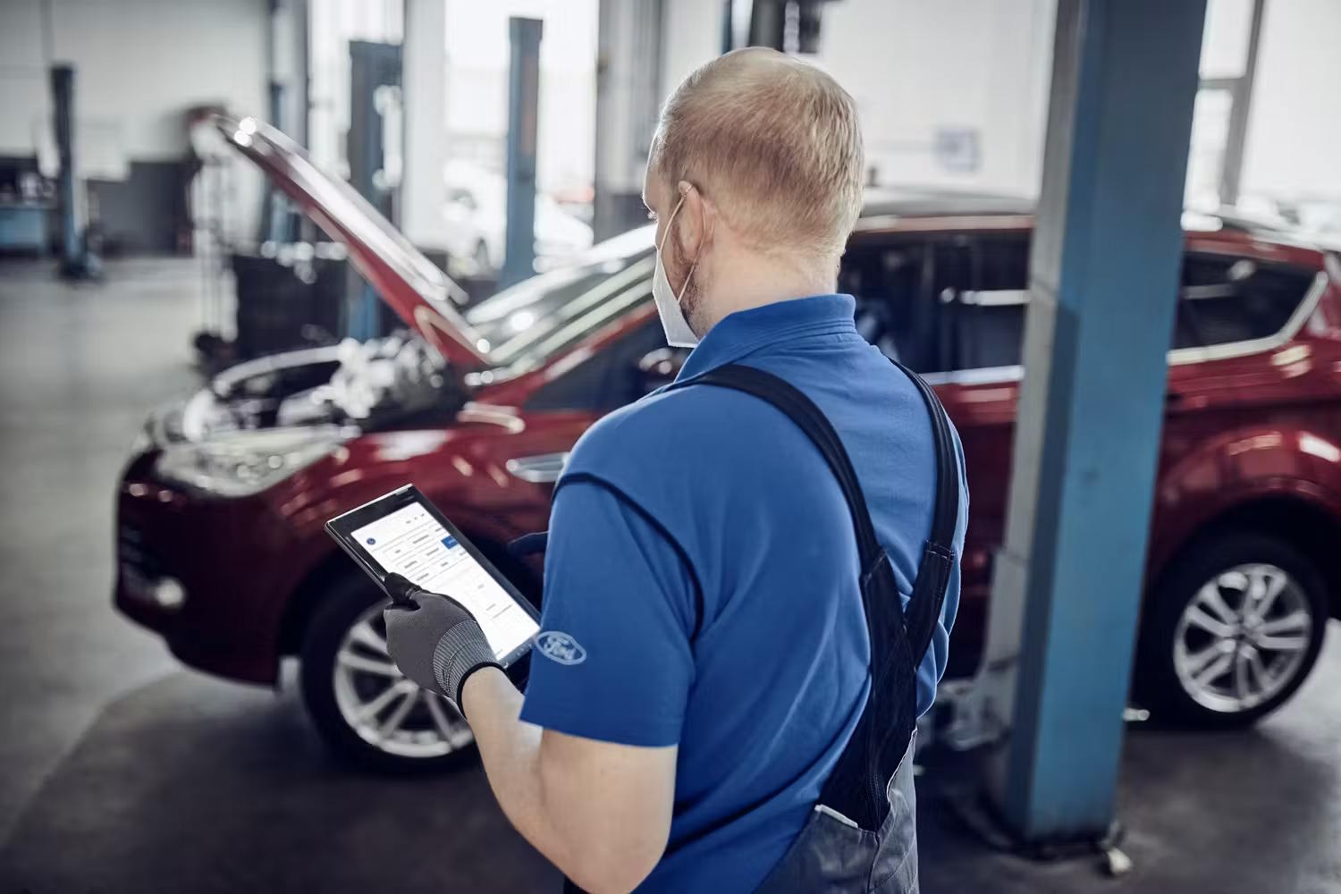 Ford service man with ipad servicing car