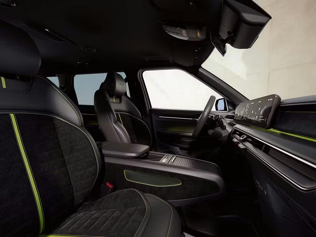 Interior view of the Kia EV9 GT from the rear passenger side, showcasing black quilted seats with vibrant lime green contrast stitching, widescreen infotainment display and panoramic roof.