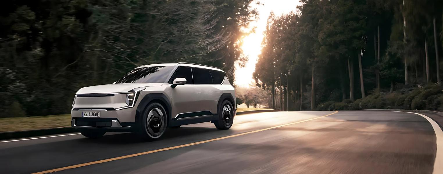Kia EV9 Driving Outdoors in a scenic forest road.