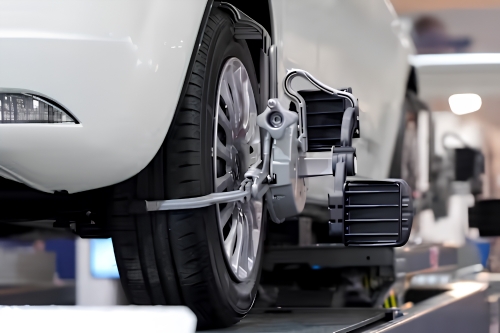 Vehicle undergoing professional wheel alignment in a dealership workshop.
