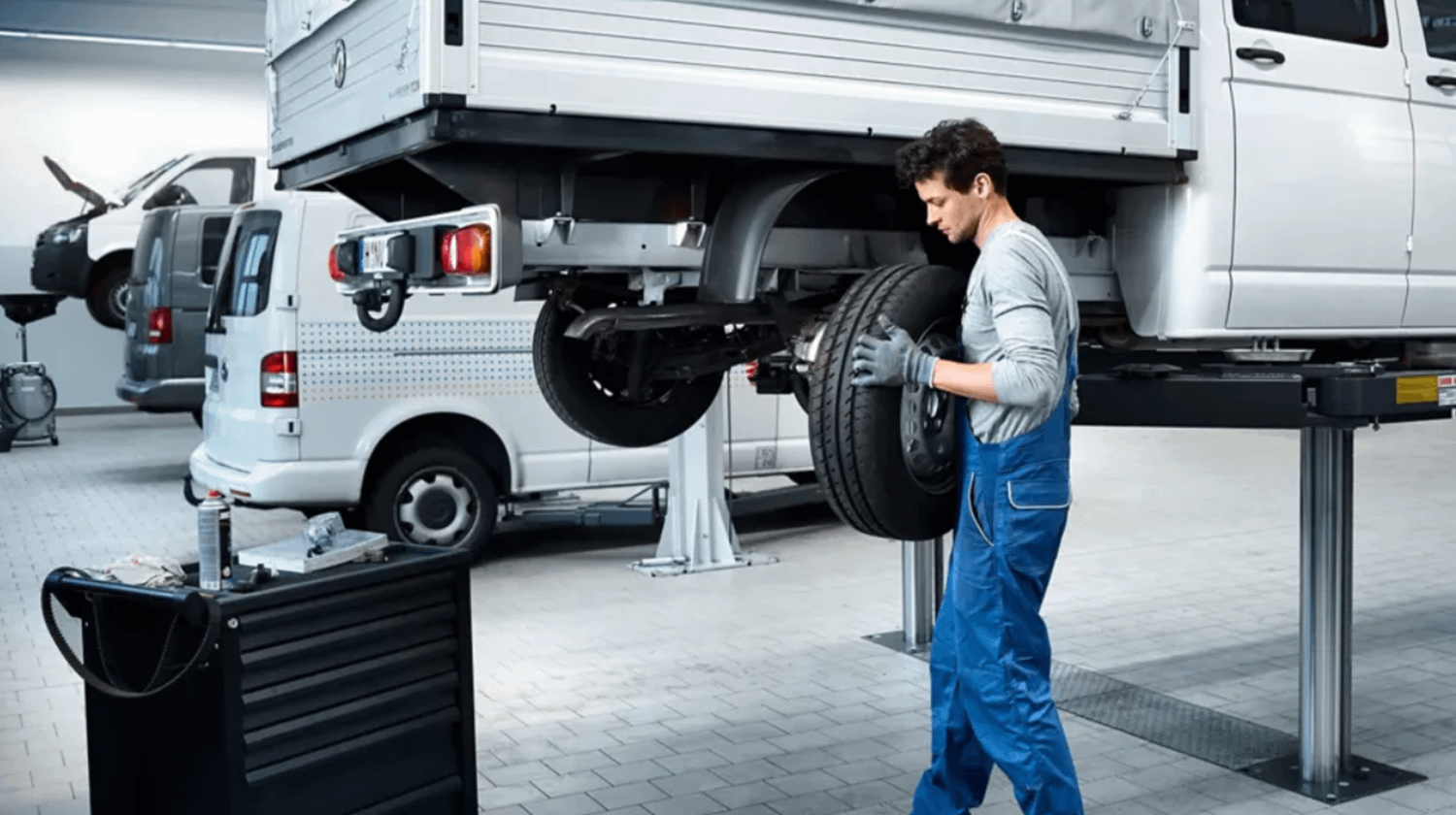 Volkswagen Mechanic taking off tyre of Volkswagen Van