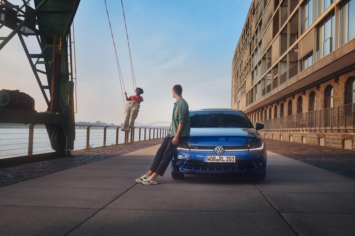 blue Volkswagen polo next to woman on swing