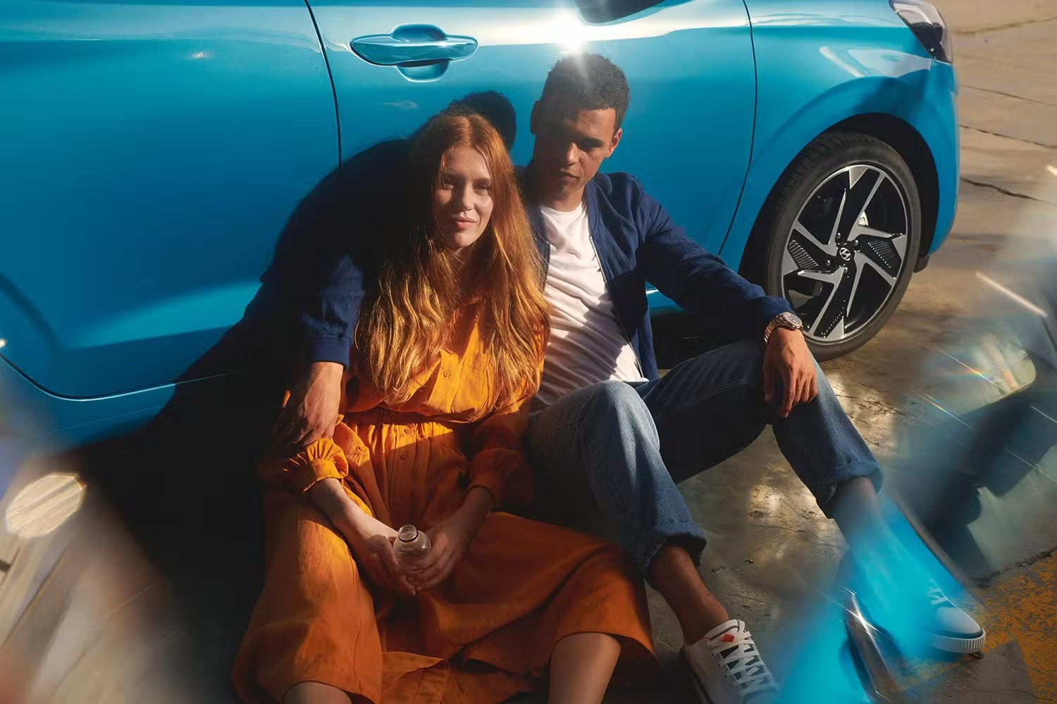People Sat Against Blue Hyundai