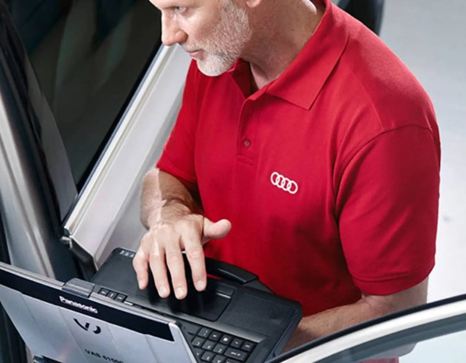 Audi Mechanic Inspecting Vehicle Holding a laptop