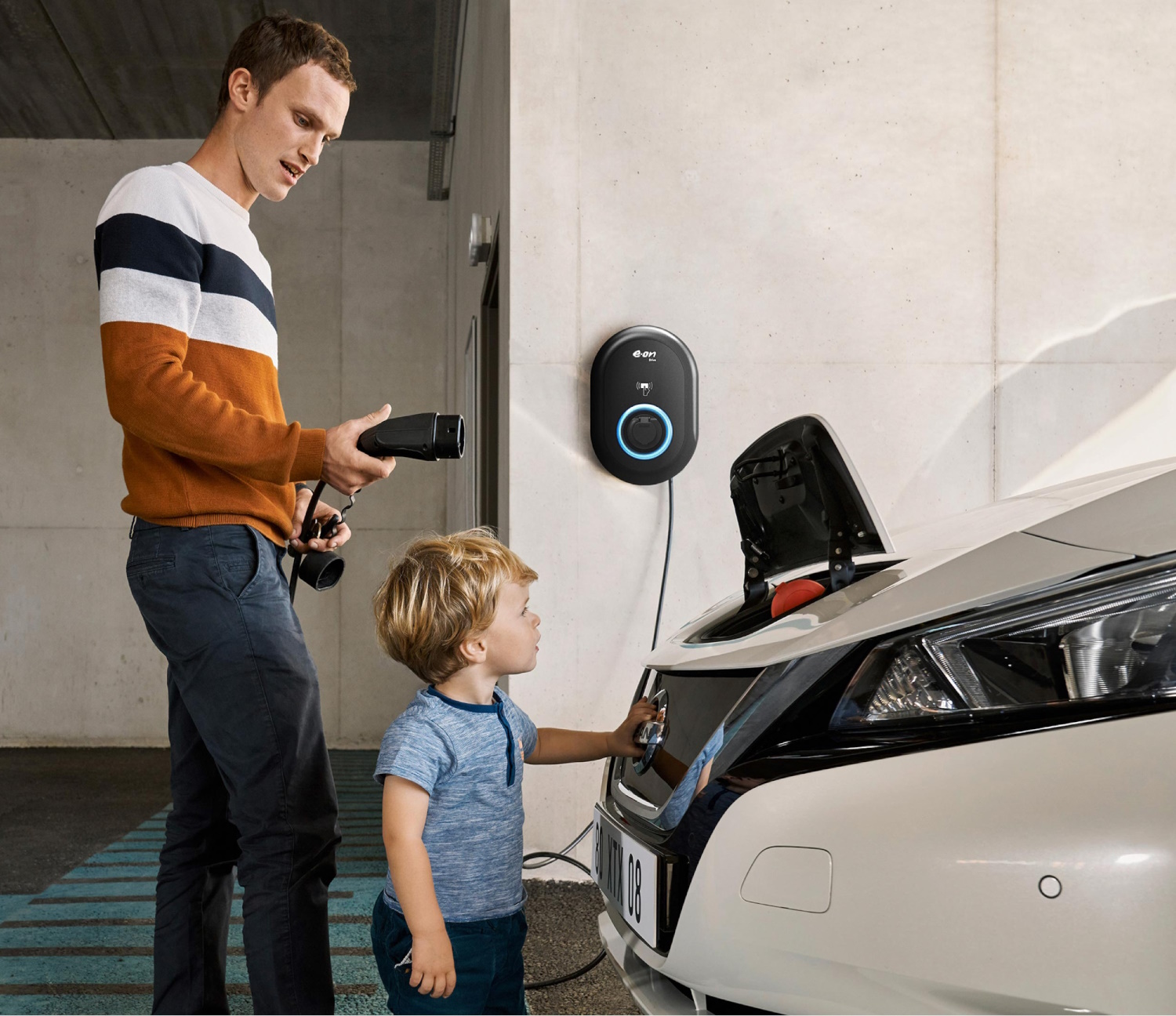 A father charging his Nissan EV using a Nissan home charging point