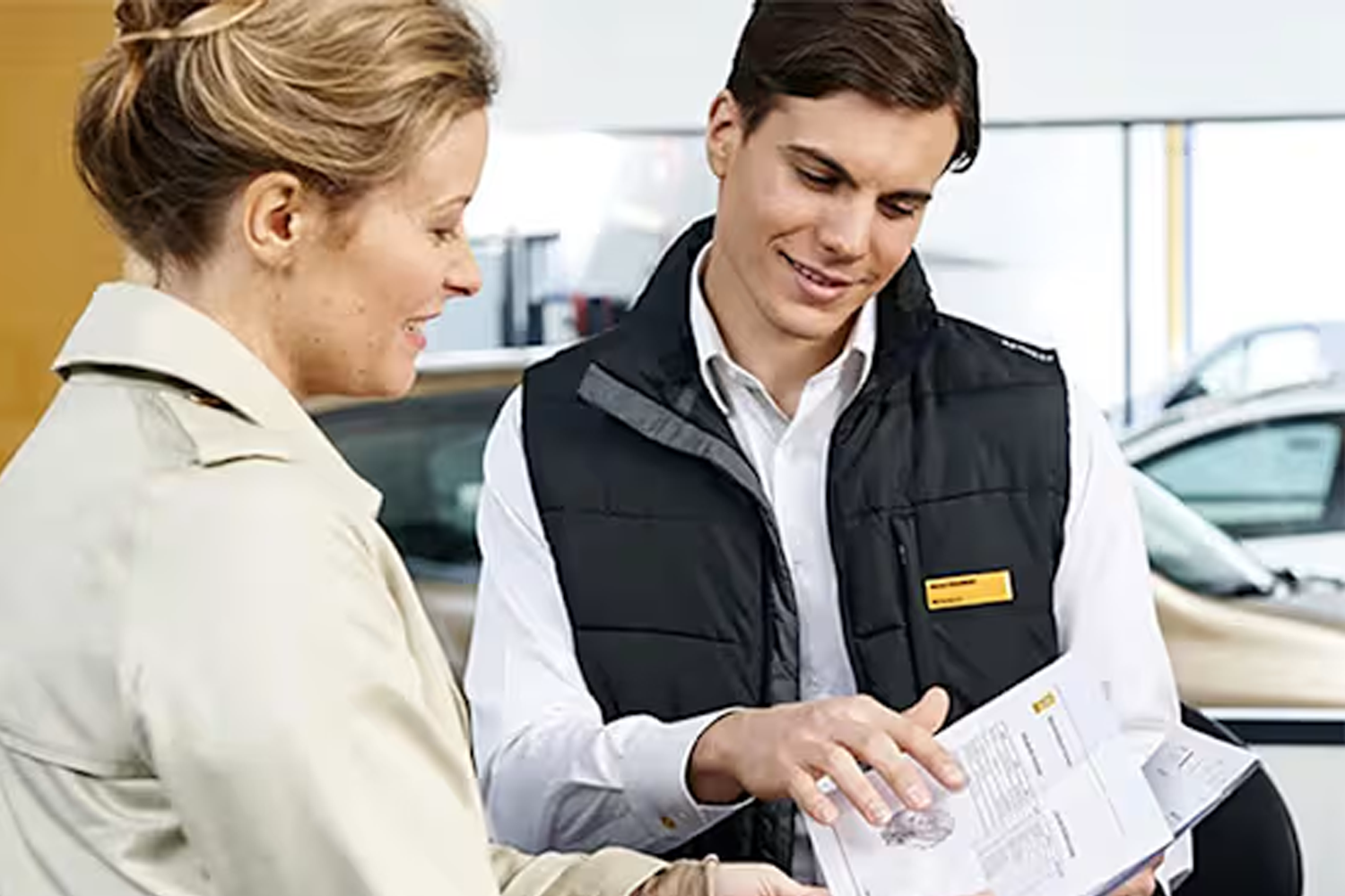 man showing a lady a renault manual