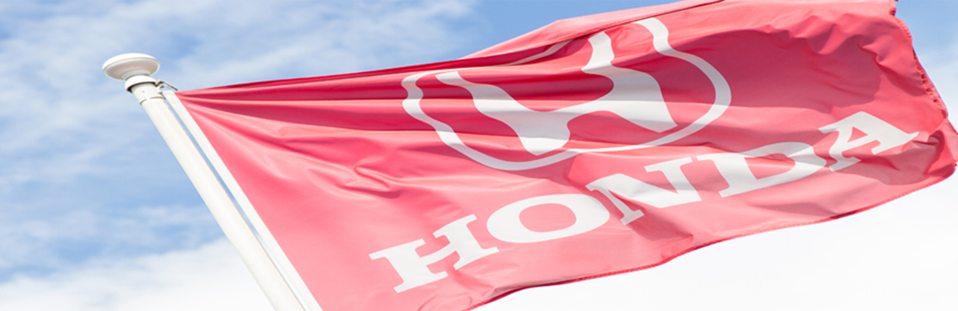 Red Honda flag waving in the wind.