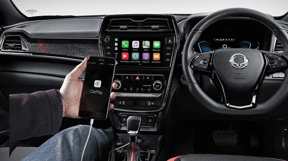 interior of the ssangyong Tivoli with a passenger using the smartphone integration options to connect to the vehicle via apple CarPlay