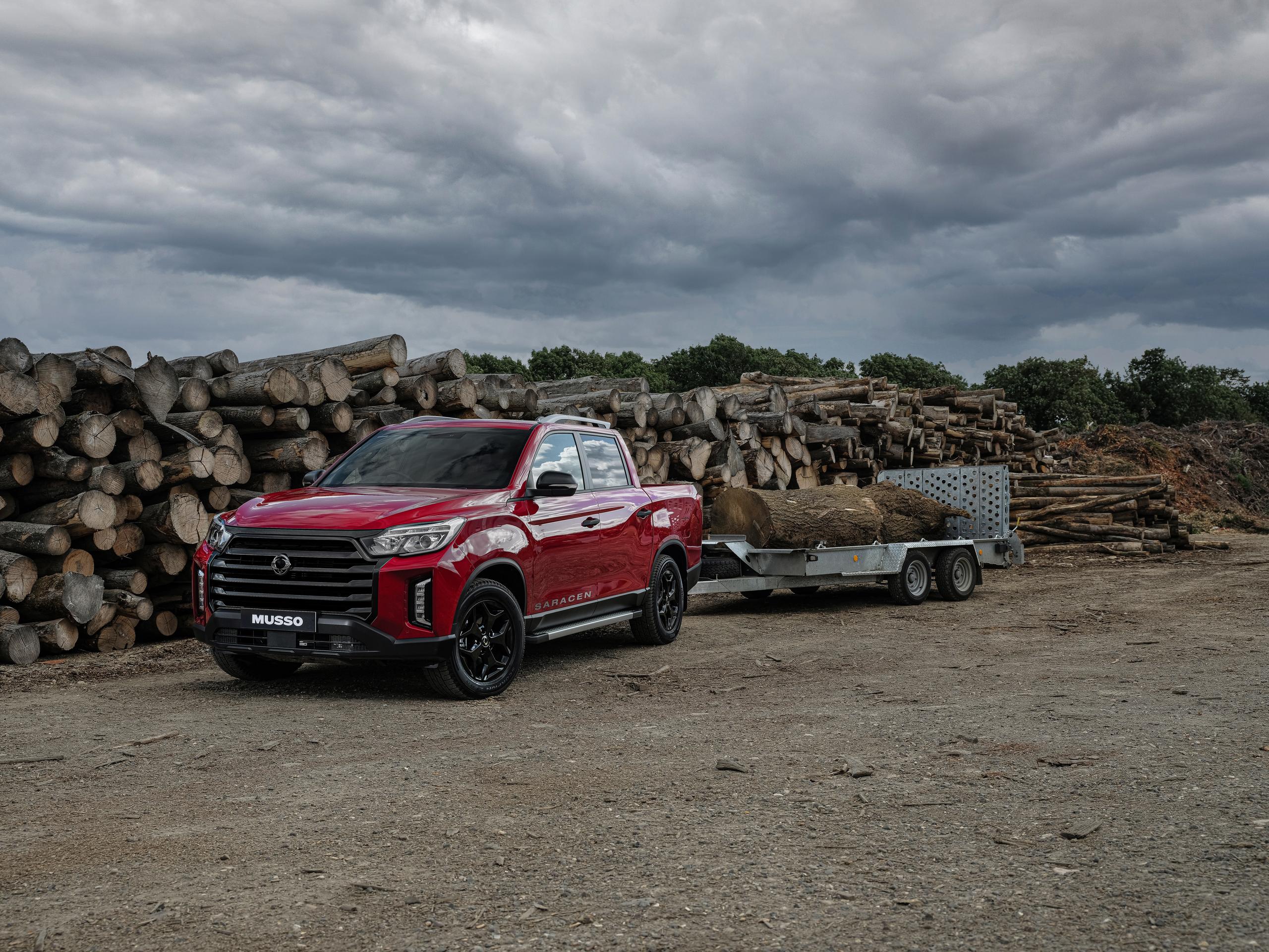 Red SsangYong Musso towing trailer