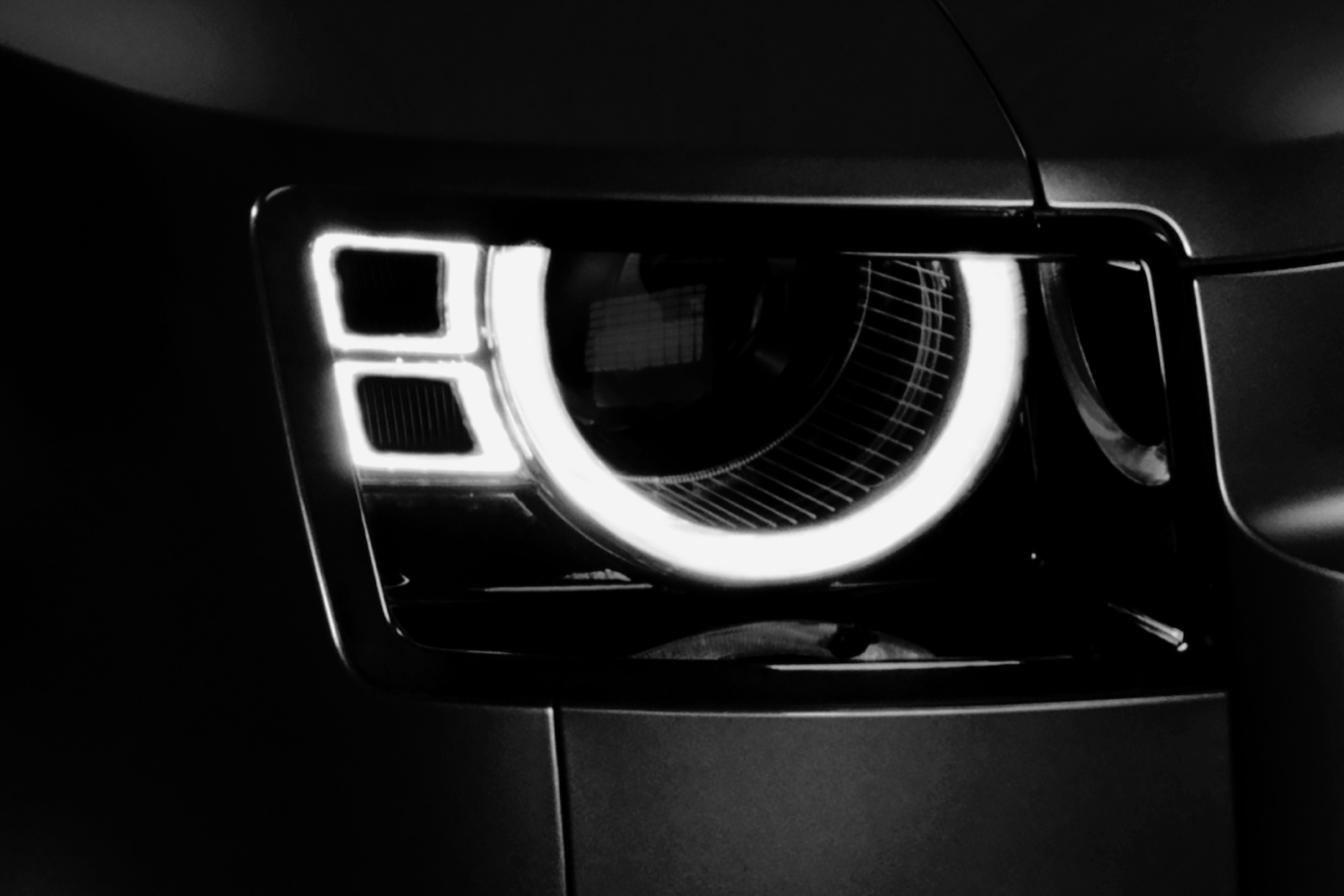 Close-up of Land Rover Defender LED headlight with signature daytime running light.