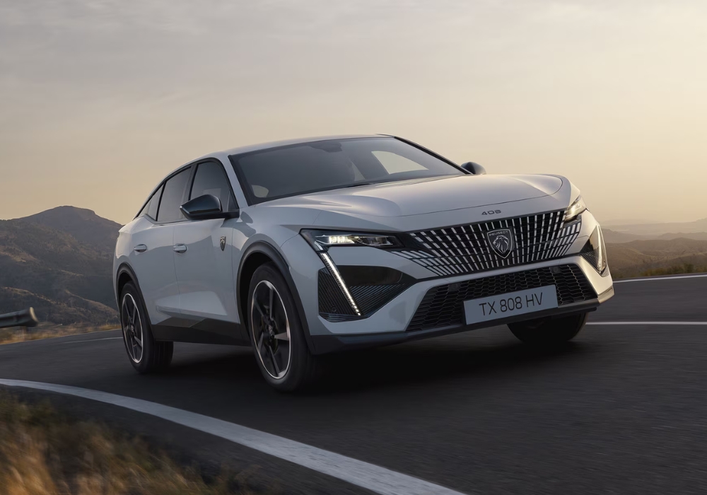 Peugeot 408 fastback in white shown from front three-quarter angle driving on a winding mountain road.