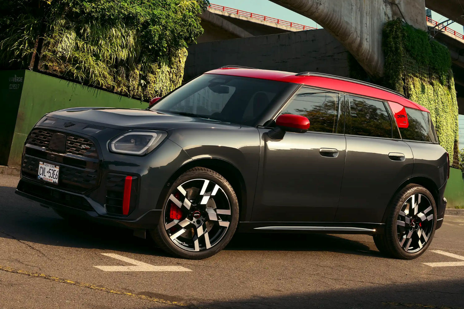 Black Mini Countryman with red roof parked in urban setting.