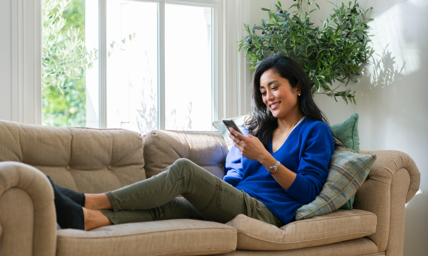 Person on phone sat on a sofa