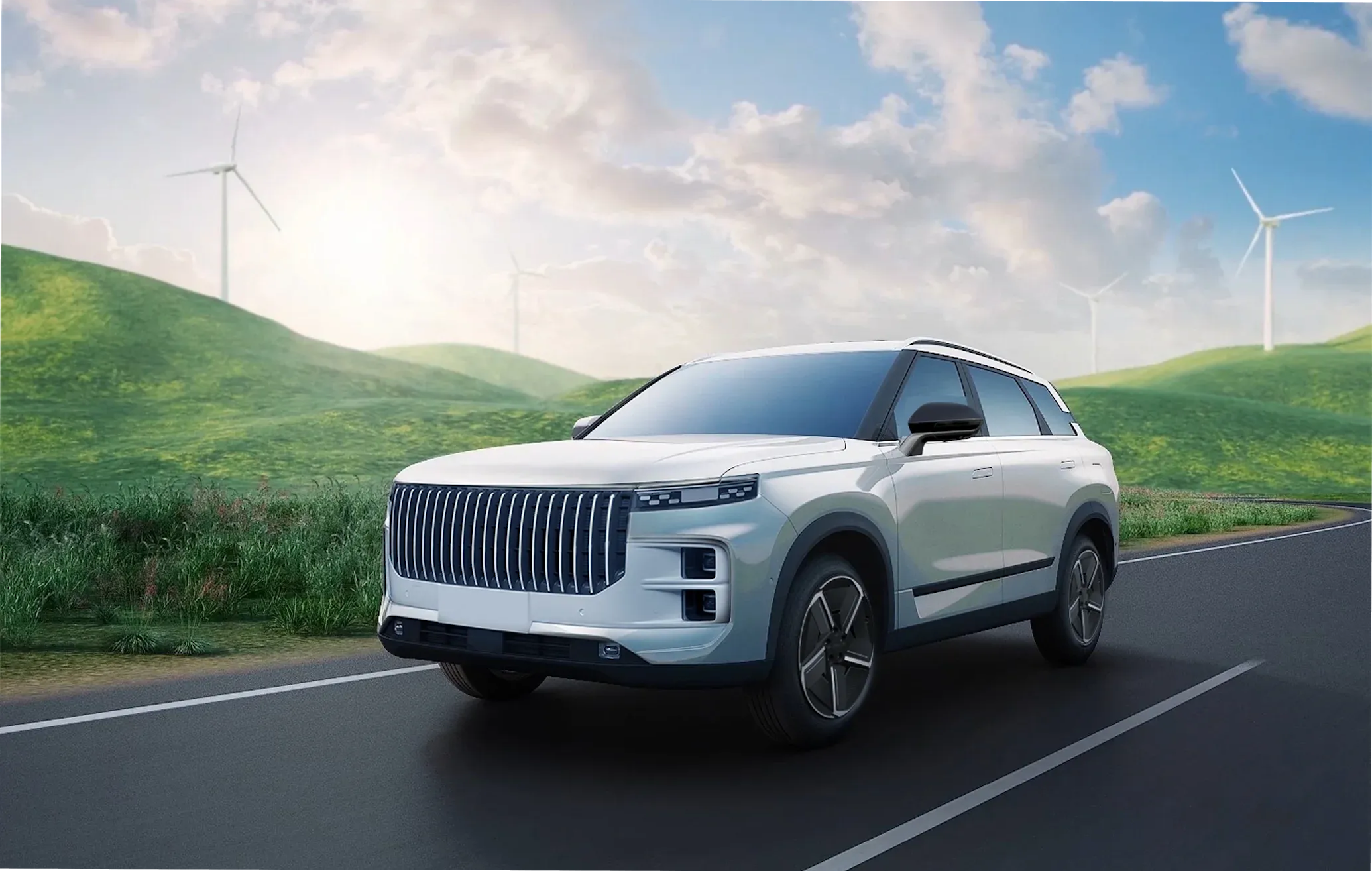 Jaecoo SUV driving along a road with green hills and wind turbines in the background, highlighting eco-friendly mobility.