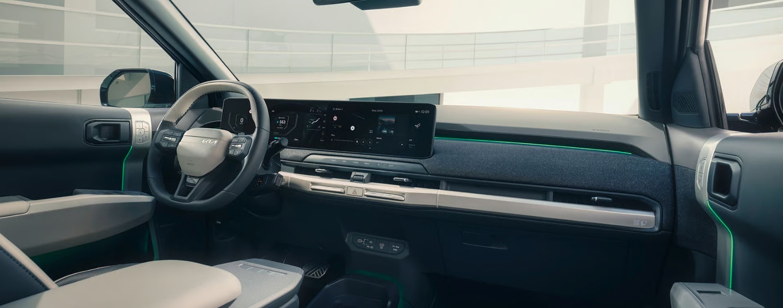 Kia EV3 Interior featuring steering wheel, large digital display screen, dashboard, and centre console.