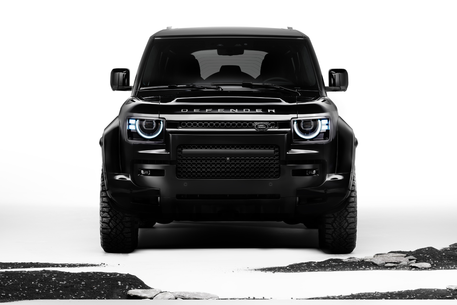 Front view of Land Rover Defender 110 in black against minimalist backdrop.