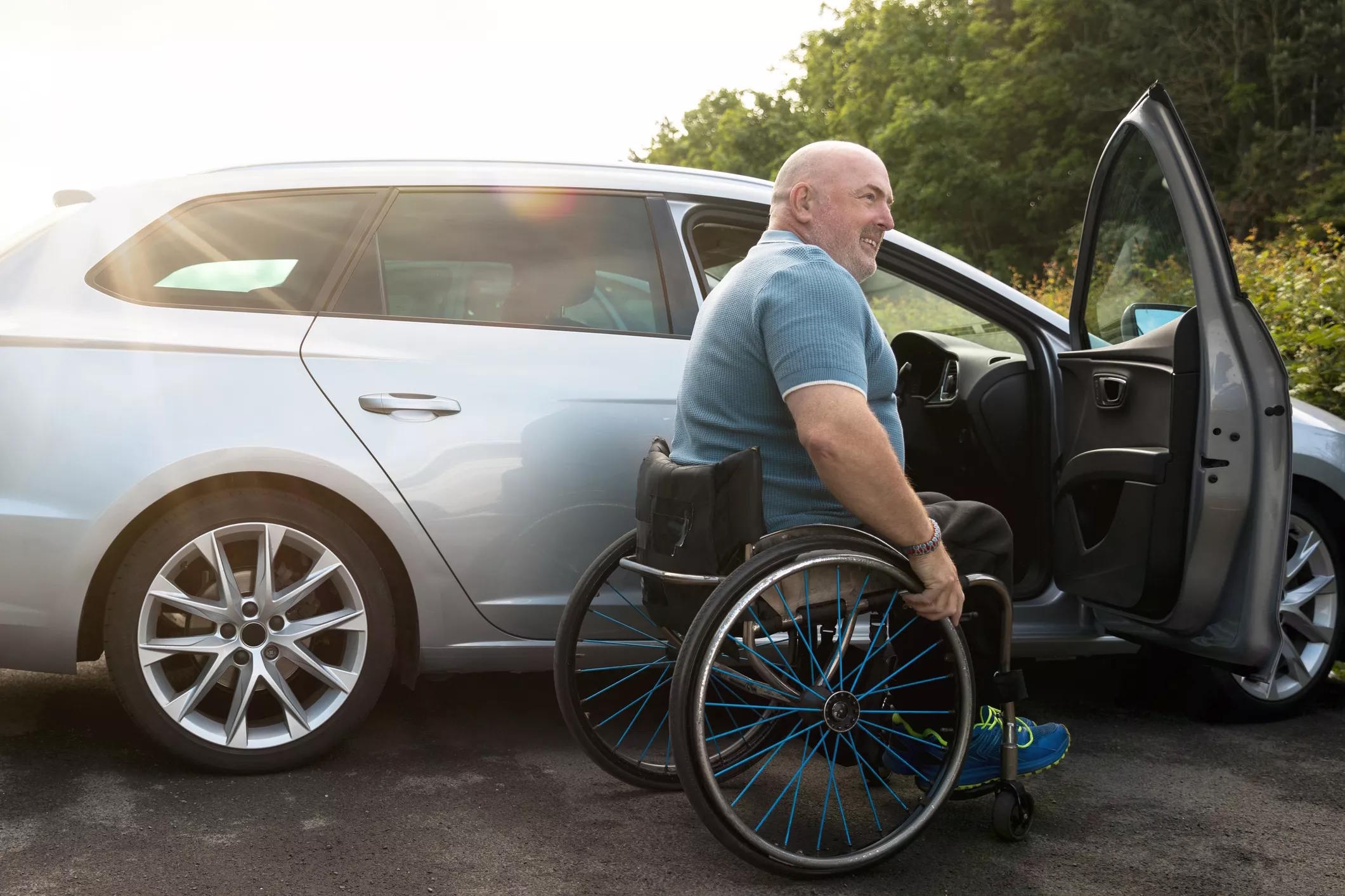 Man in wheelchair next to car