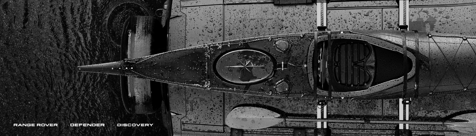 Overhead view of Land Rover Defender with kayak and adventure gear.