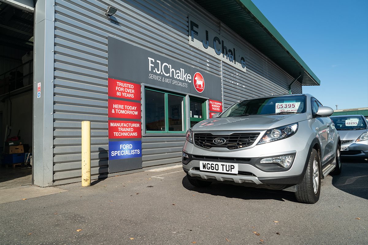 Silver Kia parked outside of FJ Chalke dealership