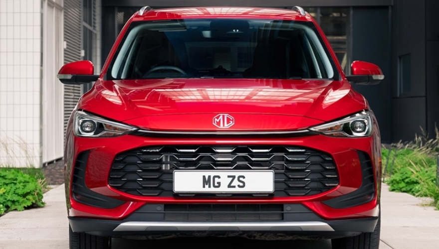 Front profile close-up of a red MG ZS parked outside.