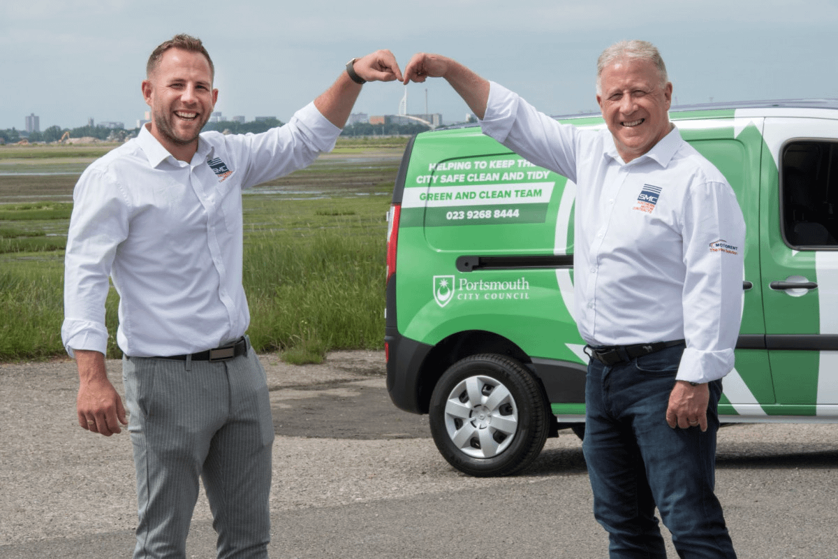 Men in front of green trucks.